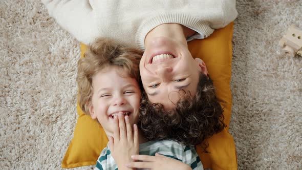 Top View of Happy Family Mom and Kid Laughing Looking at Camera at Home