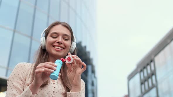 Blowing Soap Bubbles by Modern Building