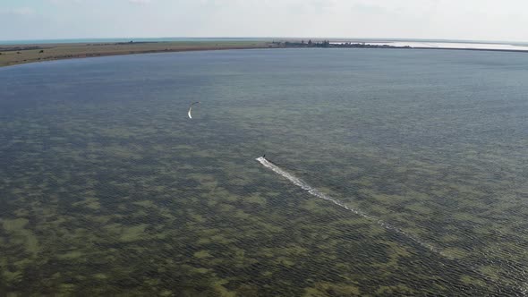 People go kitesurfing on the sea. The wind carries the athlete along the sea waves.