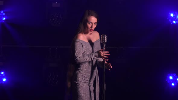 Professional Singer Sings an Emotional Song Into a Vintage Microphone in a Dark Studio. A Vocalist