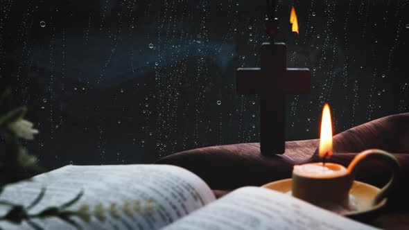 Rain and raindrops on the window, candles, crosses and bibles