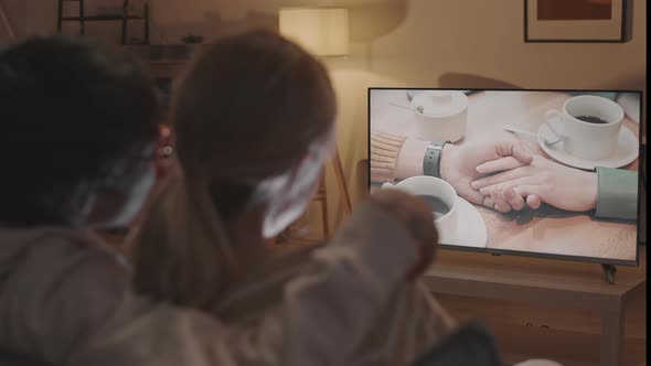 Couple Watching Romantic Movie and Whispering