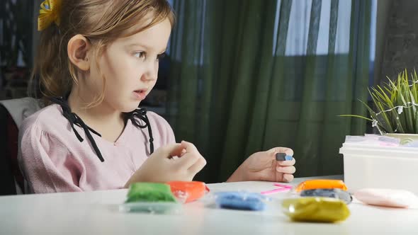 Caucasoid Girl Preschooler Sculpts with Plasticine and Talks to Someone