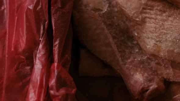 Closeup View of Hands in Gloves Packing Chicken Legs From a Box Into Individual Plastic Bags