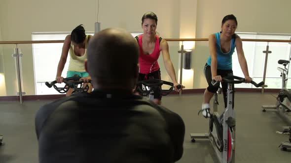 Spinning class with male coach in gym