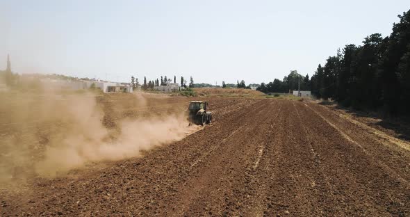 Aerial view of a tractor ploughing an empty field, Kibbutz saar, Israel.