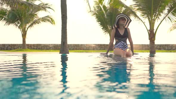 Young asian woman enjoy around outdoor swimming pool for leisure