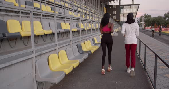 Black Sporty Girls Jogging Near Stadium Rows