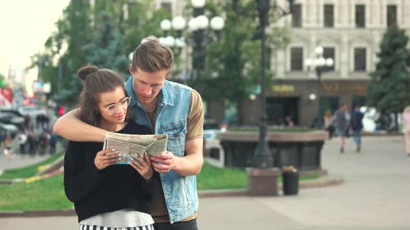 Young Couple of Tourists Looking at Map