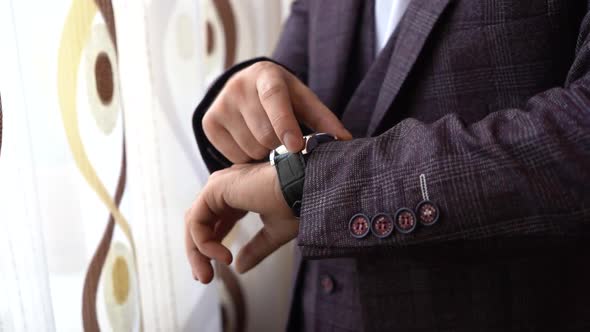 Man with watch on his hand. Groom before wedding ceremony.  