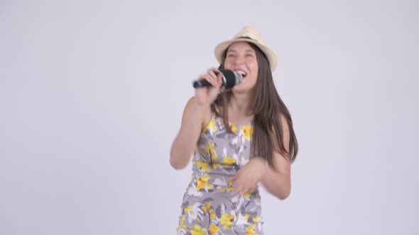 Young Happy Multi-ethnic Tourist Woman Singing with Microphone
