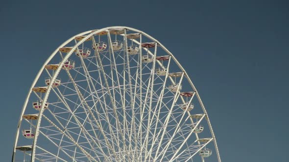 Rotation of Ferris Wheel on Blue Sky Background