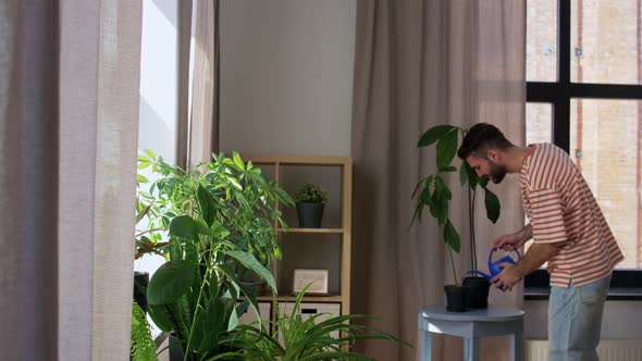 Happy Smiling Man Watering Flowers at Home