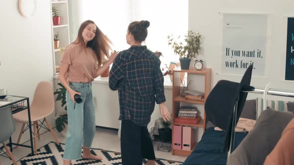 Teenage Girls Dancing to Music in Bedroom