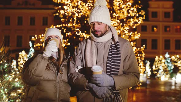 Couple with Coffee Talking in City on Christmas