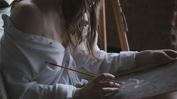 Girl Painter Paints a Picture in the Home Studio.