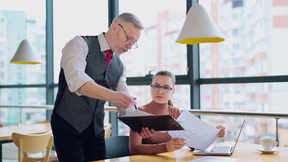 Mature entrepreneur explaining the work to a secretary