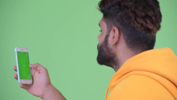 Closeup Rear View of Young Overweight Bearded Indian Man Using Phone