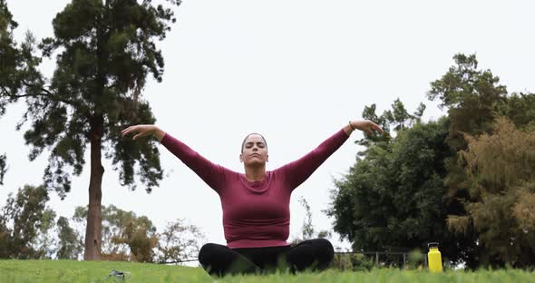 Young curvy woman doing yoga exercise outdoor