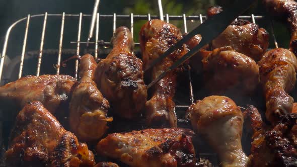 Closeup of Mouthwatering Chicken Legs Roasted and Flipped on a Grill