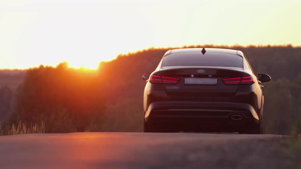 The Car Drives Into the Sunset the Evening Light is Reflected in the Asphalt