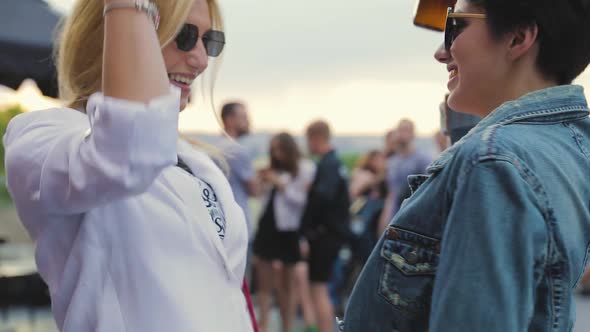 Smiling Women Having Fun, Drinking Beer And Dancing Outdoors