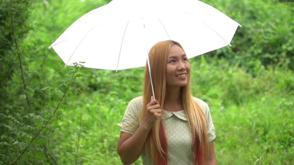 Woman walking hand holding white umbrella under rain