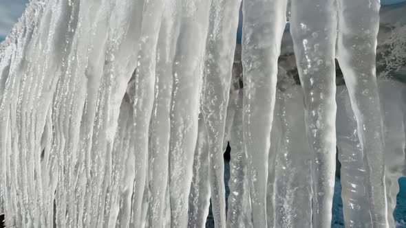 Large Icicles Melting Hanging From Metal Railing