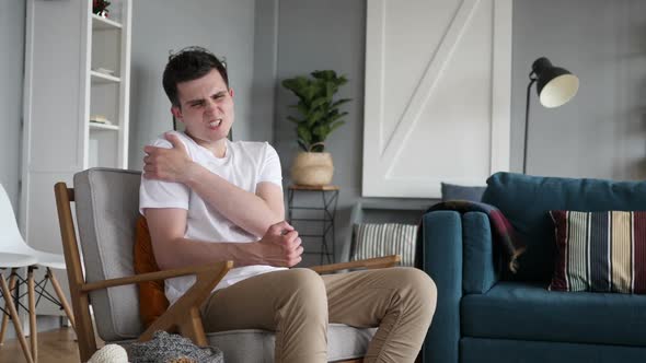 Man with Shoulder Pain Sitting on Couch