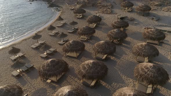 Aerial view of empty beach with straw umbrellas on Achaia, Greece.