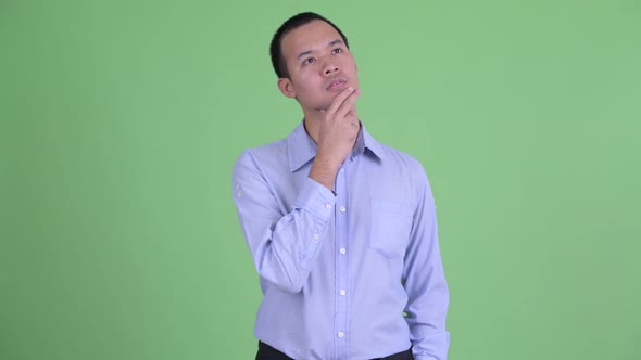 Studio Shot of Stressed Asian Businessman Thinking and Looking Down