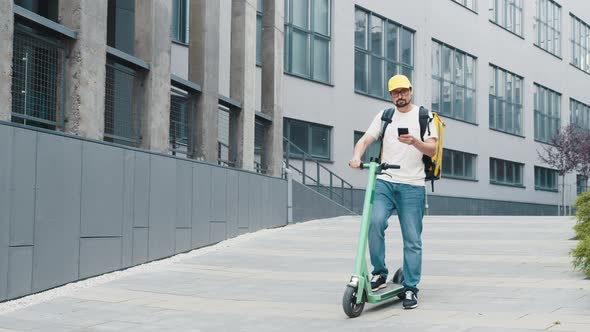 Man Courier Food Delivery Standing with Electric Scooter and Thermal Backpack