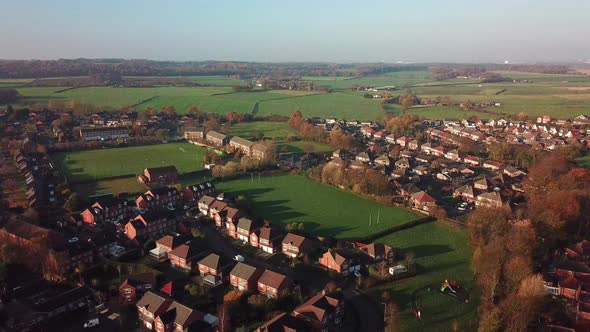 Ascending shot over British small town on edge of countryside.