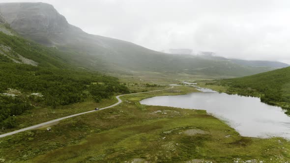 Car Driving At The Foothill Of The Lush Mountain Passing Through Hydalen Valley In Hemsedal, Norway