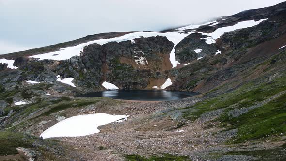 Hikers trekking to the edge of the picturesque Crater Lake near Smithers, British Columbia, in Canad