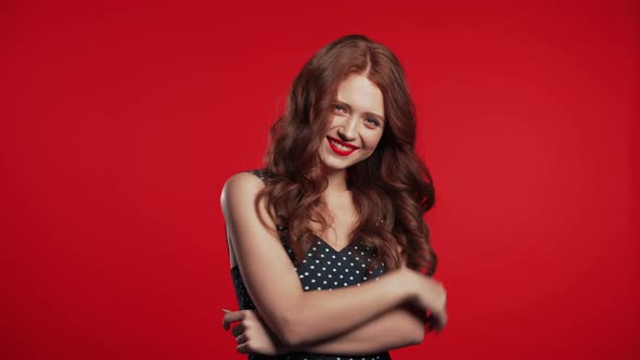 Pretty Girl with Red Hair Standing on Studio Background, Smiling and Flirting