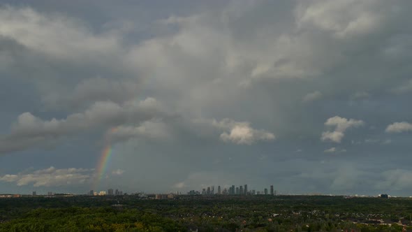 Fluffy Clouds With Rainbow After Rain With Skyline In The Distance. - timelapse