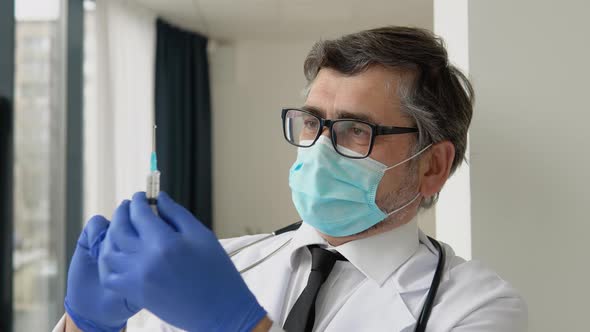 Senior Male Doctor Preparing Vaccination Syringe