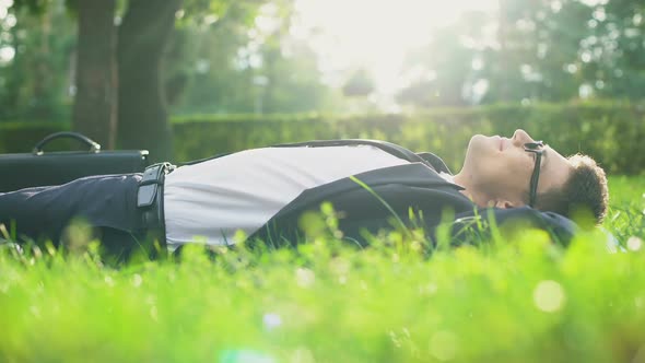 Happy Man in Suit Lying on Grass and Enjoying Sunny Day, Harmony With Nature