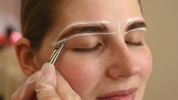 The Master Draws the Shape of the Eyebrows with White Paint Before Coloring