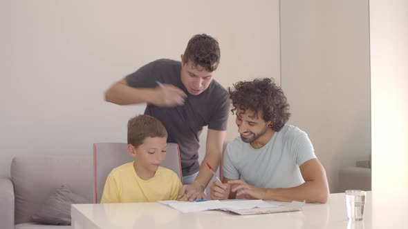 Fathers Helping Son with Writing Task