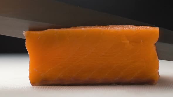 Chef Cutting the Salmon Fillet on Slices for Cooking Sushi