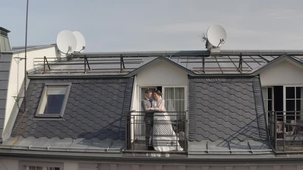 Caucasian Newlyweds Bride Embracing Groom on Balcony in Hotel Room Aerial View