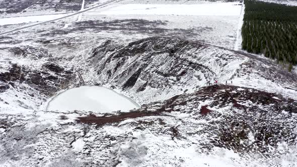 Tourists Looking in to the Snowy Kerid Crater in Iceland Seen From the Air