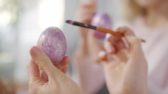 Unrecognizable Woman Putting Glitter on Easter Egg