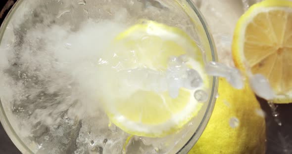 Top View of a Glass of Soda in the Shade of a Palm Leaf with Falling Lemon Slice