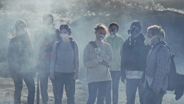 Portrait of people in gas mask standing in clouds of toxic smoke.