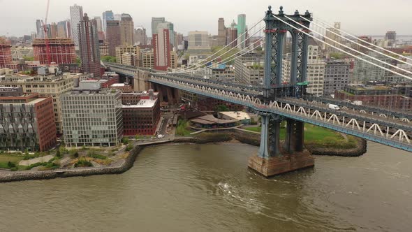 An aerial view over the East River on a cloudy day. The drone camera dolly in along the north side o