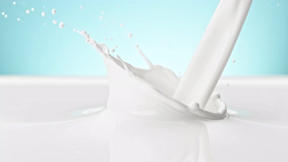 Super Slow Motion Shot of Pouring and Splashing Fresh Milk on Blue Background at 1000 Fps