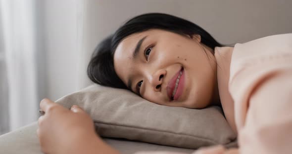 Thai woman laying on sofa.